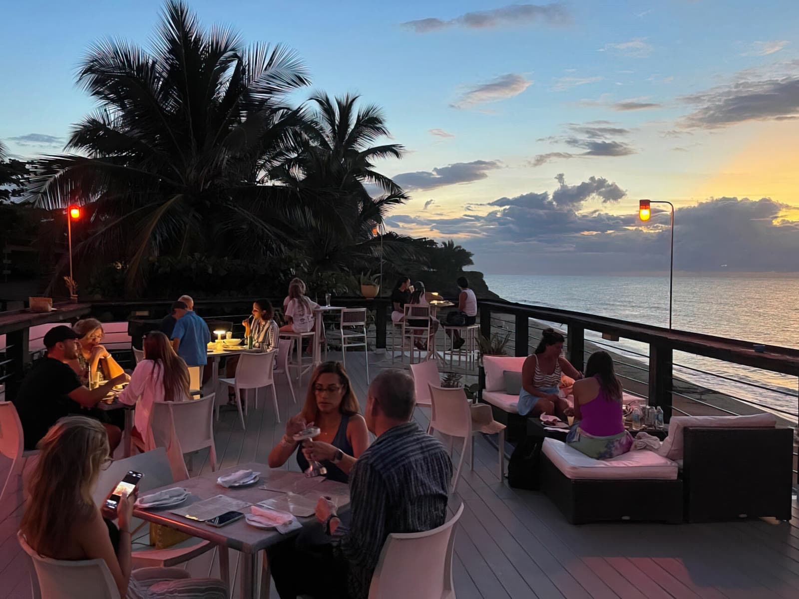 Terraza de Tamboo ocupada durante el atardecer frente al mar