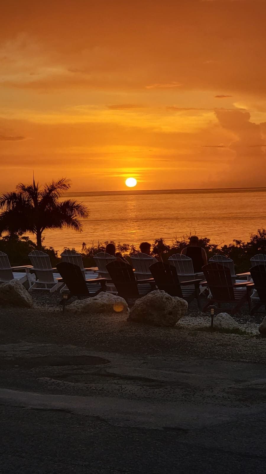 Atardecer naranja sobre el océano desde la terraza de The Beach House