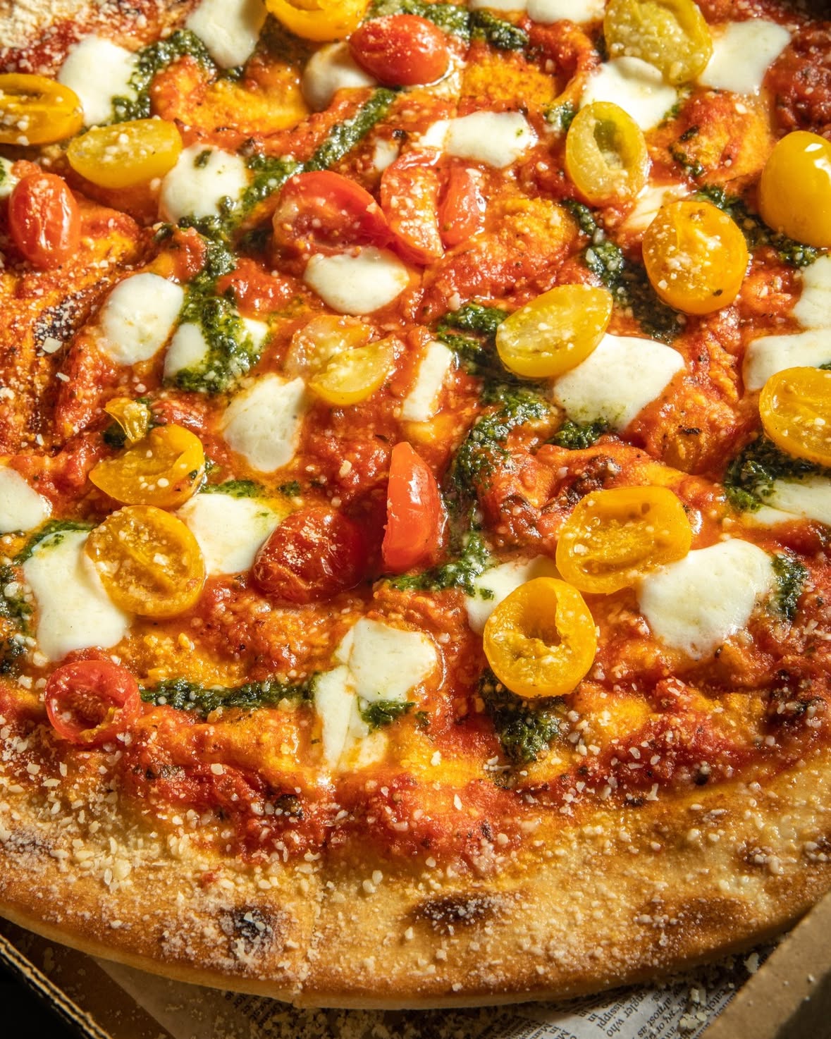 Tomates, mozzarella y pesto sobre masa fina
