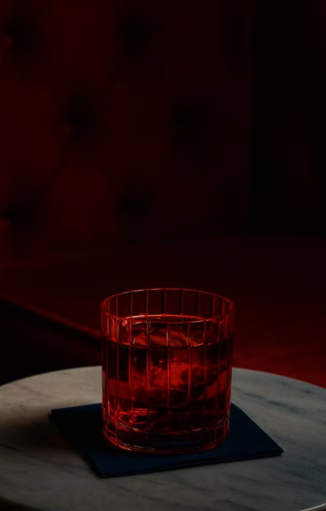 Coctel rojo servido sobre una mesa del speakeasy Furtivo