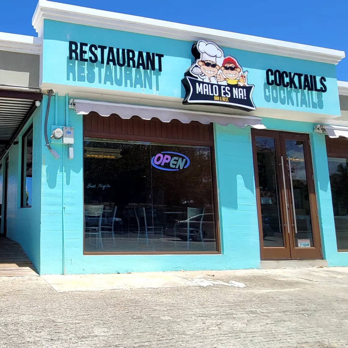 Fachada azul del restaurante y barra Malo es Na en Base Ramey